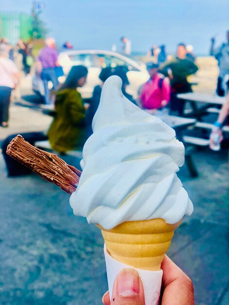 Foto imagen recortada de una mano sosteniendo helado