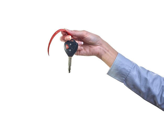 Imagen recortada de la mano sosteniendo la llave del coche contra un fondo blanco