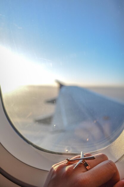 Foto imagen recortada de la mano en la ventana de un avión