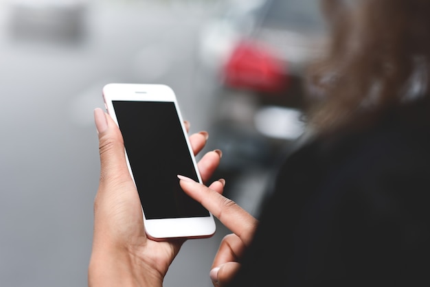 Imagen recortada de manos de mujer sosteniendo un teléfono inteligente con pantalla de espacio de copia en blanco para mensajes de texto