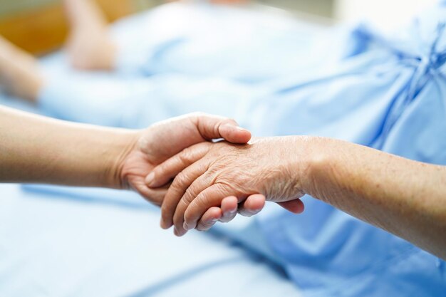 Foto imagen recortada de un médico y un paciente tomados de la mano en un hospital