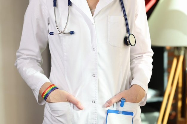 Imagen recortada de médico con pulsera lgbt en la mano