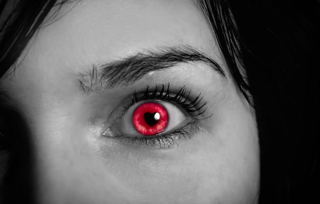 Imagen recortada de una mujer adulta de ojos espeluznantes rojos