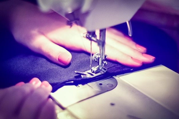 Imagen recortada de una mujer cosiendo tela en una máquina de coser