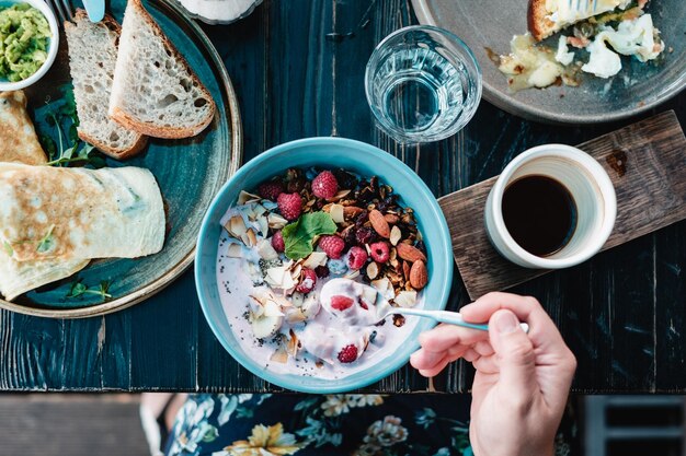 Foto imagen recortada de una mujer desayunando en la mesa