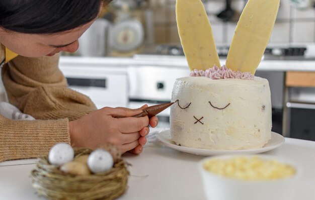 Imagen recortada de una mujer horneando y decorando pasteles en la cocina de casa.