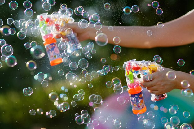Foto imagen recortada de una mujer jugando con pistolas de burbujas