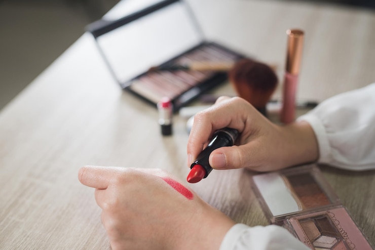 Foto imagen recortada de una mujer con lápiz labial en la mesa