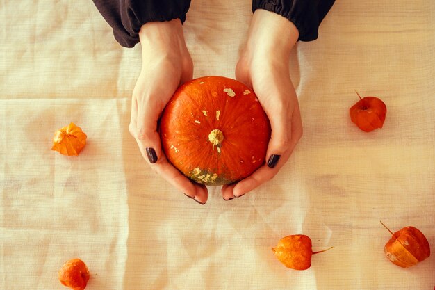 Imagen recortada de una mujer sosteniendo una calabaza en sus manos