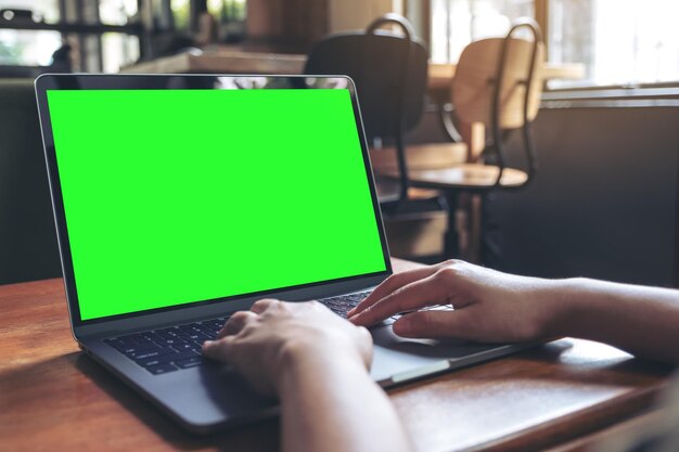 Foto imagen recortada de una mujer usando una computadora portátil en un café