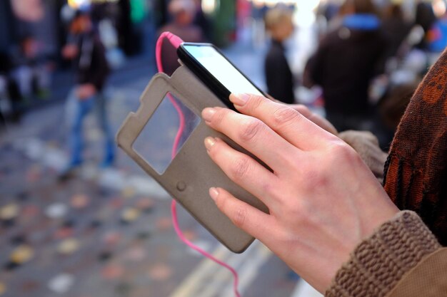 Foto imagen recortada de una mujer usando el teléfono en la acera