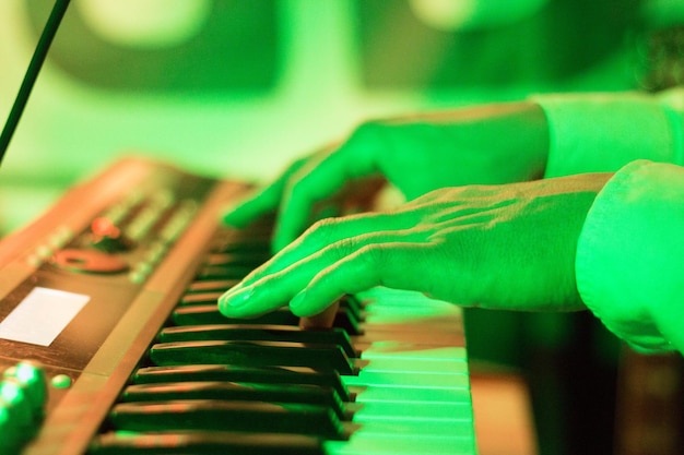 Foto imagen recortada de un músico tocando un teclado musical en un restaurante