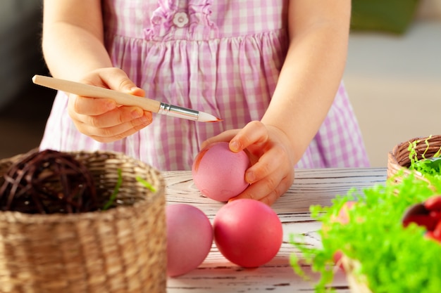 Foto imagen recortada de una niña pintando huevos para pascua