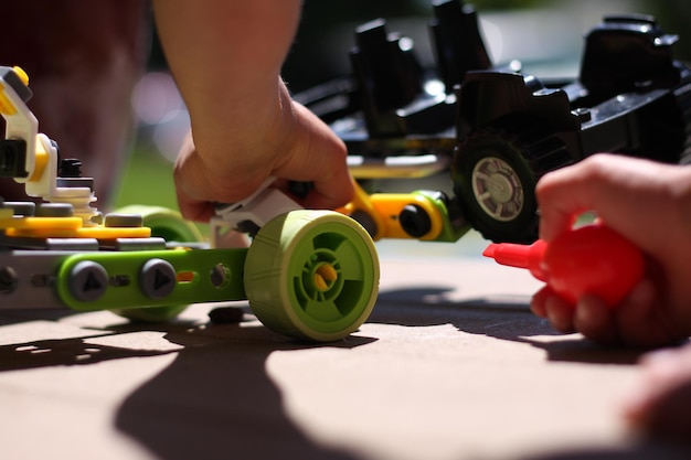 Imagen recortada de un niño jugando con coches de juguete