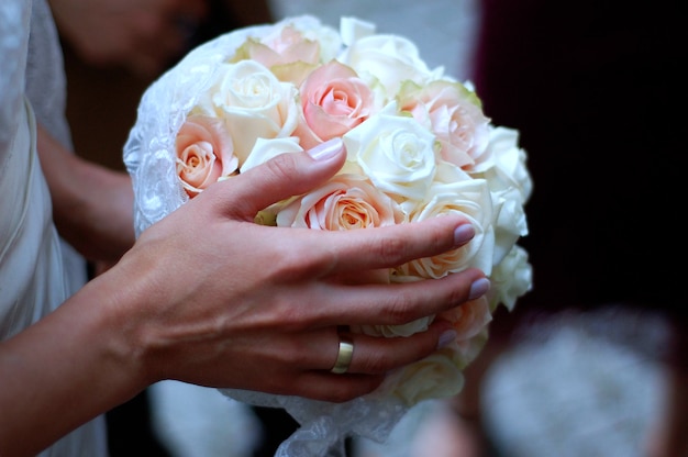 Imagen recortada de la novia sosteniendo un ramo de rosas en la boda
