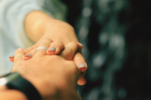 Imagen recortada de una pareja tomándose de la mano