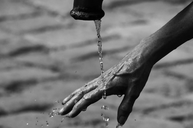 Foto imagen recortada de una persona lavando la mano bajo un grifo