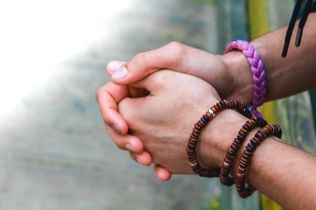Imagen recortada de una persona con las manos juntas usando pulseras