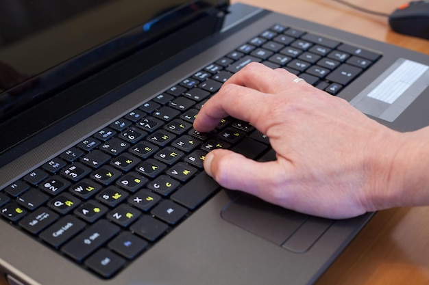 Foto imagen recortada de una persona usando una computadora portátil en la mesa