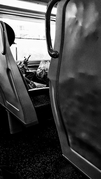 Imagen recortada de una persona usando un teléfono móvil mientras viaja en tren