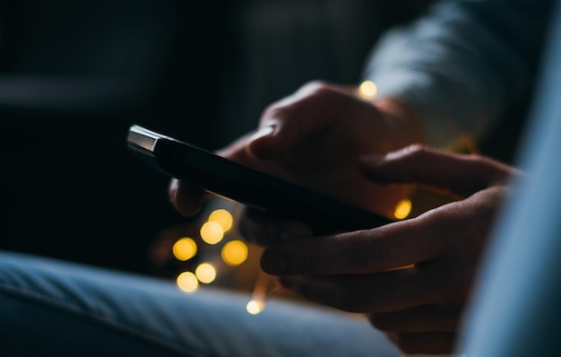 Imagen recortada de una persona usando el teléfono por la noche