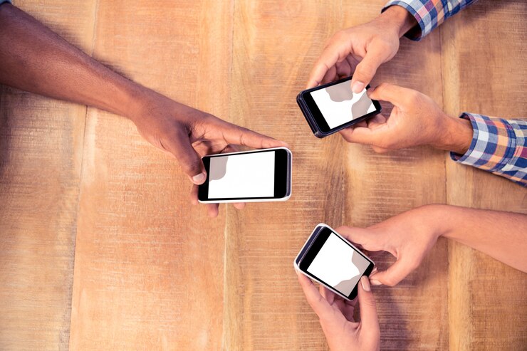 Foto imagen recortada de personas de negocios que usan teléfonos inteligentes en la mesa