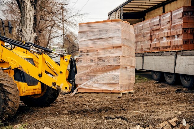 Foto imagen recortada de una pila de elevación de elevación de ladrillos en el sitio de construcción