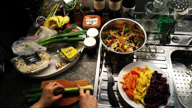 Foto imagen recortada de verduras cortadas a mano en la cocina