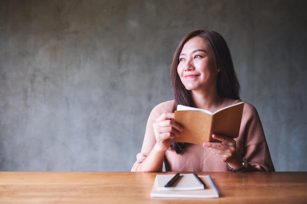 Imagen de retrato de una hermosa joven asiática leyendo un libro