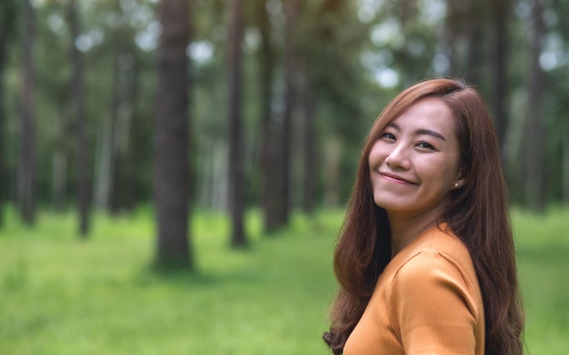Imagen de retrato de una hermosa joven asiática parada en el parque