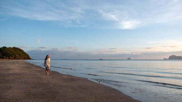 Imagen de retrato de una hermosa joven asiática paseando por la playa junto al mar