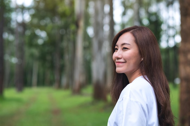 Imagen de retrato de una hermosa mujer asiática de pie en el parque