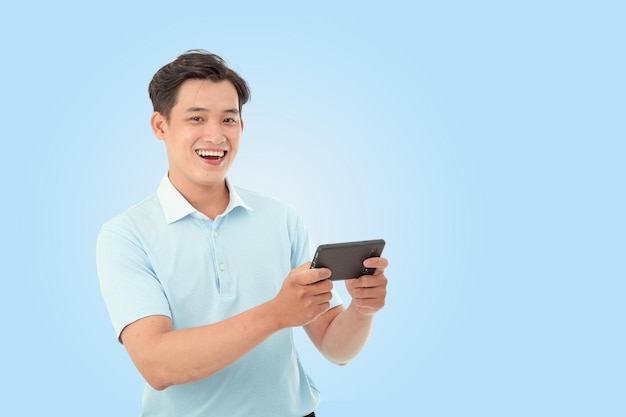 Imagen de retrato horizontal de un joven feliz en el estudio sobre un fondo azul claro