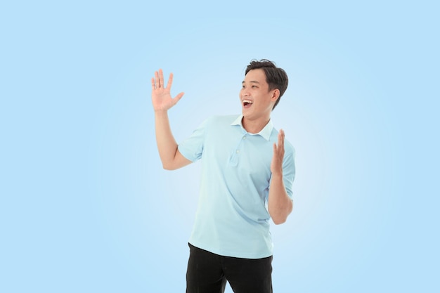 Imagen de retrato horizontal de un joven feliz en el estudio sobre un fondo azul claro