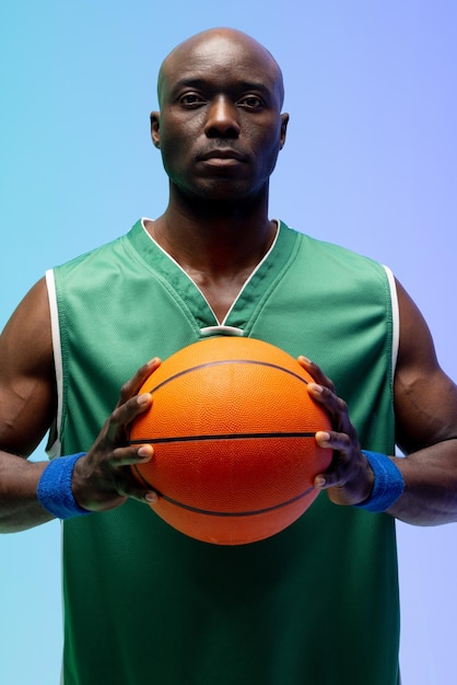 Imagen del retrato del jugador de baloncesto afroamericano con baloncesto sobre fondo verde a azul