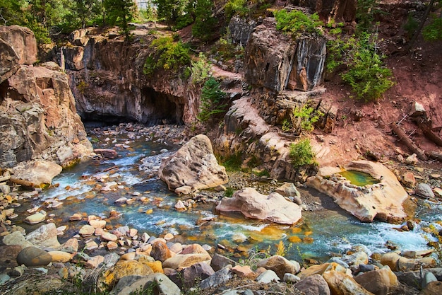 Imagen de un río que serpentea a lo largo del cañón con un sendero que conduce a una fuente termal oculta