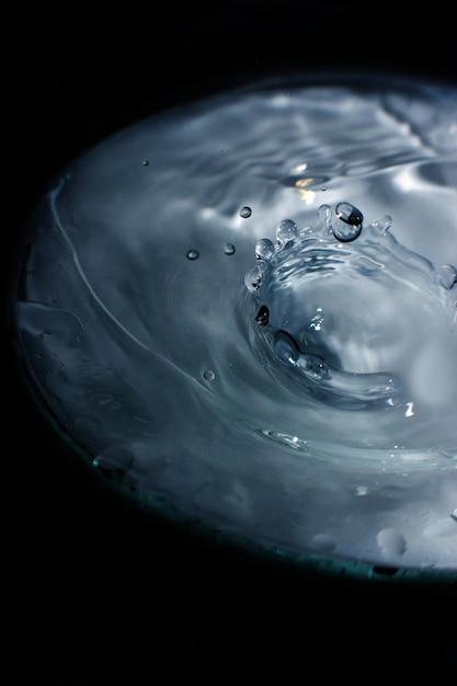 Imagen de salpicaduras de agua en una piscina con un fondo negro