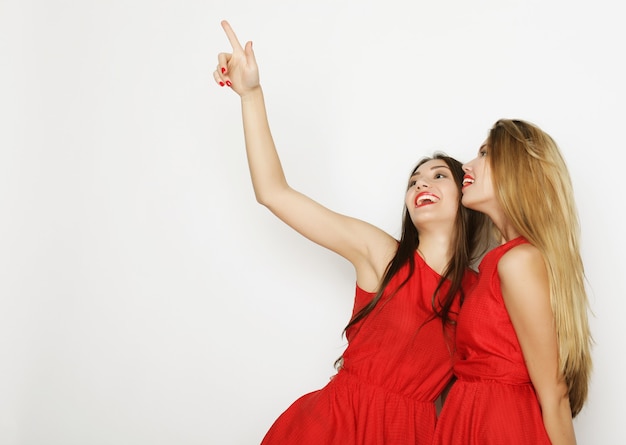 Imagen de una sensual jovencita en vestido rojo en la pared blanca