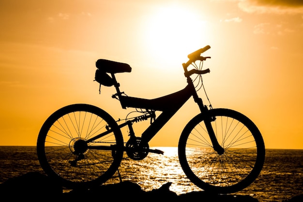 Foto imagen de una silueta de bicicleta de montaña al atardecer