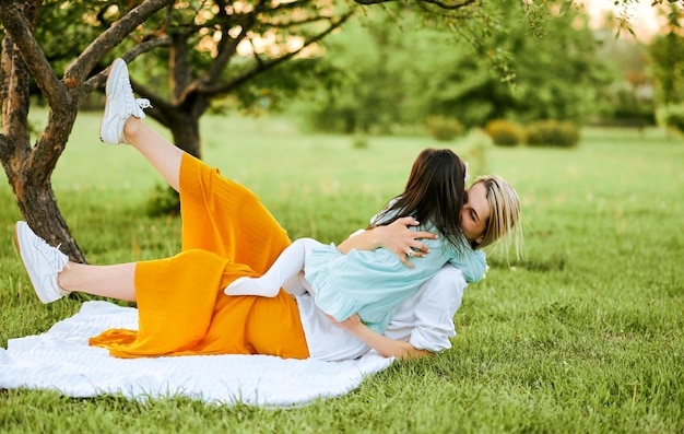 Imagen sincera al aire libre de un niño feliz jugando con su madre disfrutando el tiempo juntos Linda niña abrazando a su madre en el parque Madre e hija comparten amor Día de la madre