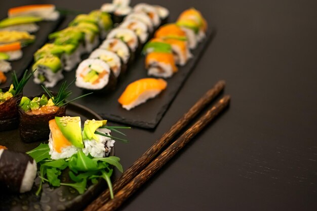 Imagen de Sushi lujoso y creativo como NigiriFutomakiUramaki con palillos y Soja