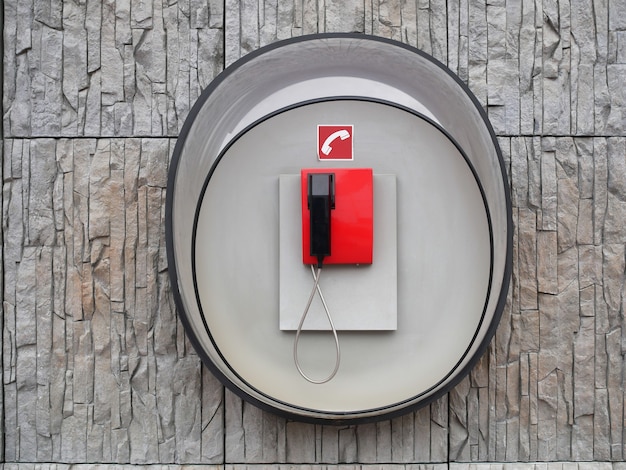 Imagen de teléfono rojo en la pared del edificio moderno