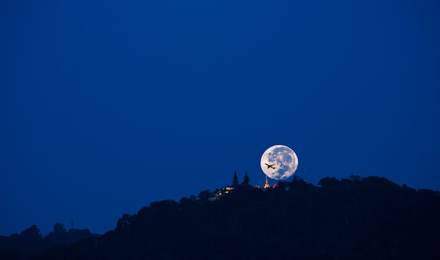 Foto imagen de tiro silueta de luna grande y sombra de avión