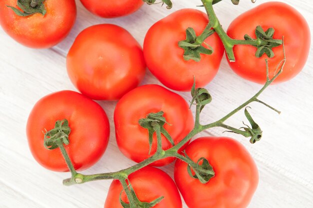 Imagen de tomates de vid sobre un fondo blanco de madera