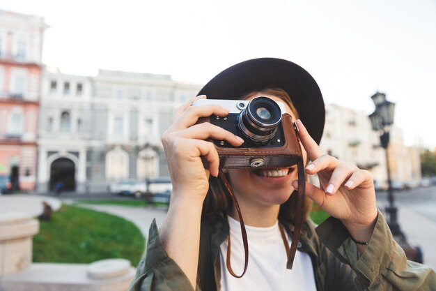 Imagen de un turista de fotógrafo bastante joven y bella mujer caminando al aire libre en un hermoso día de primavera sosteniendo la cámara.