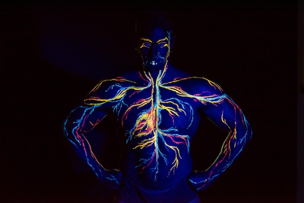 Imagen UV del arte corporal del sistema circulatorio en el cuerpo de un hombre adulto En el pecho de un atleta musculoso, las venas y las arterias se dibujan con tintes fluorescentes Luz de neón