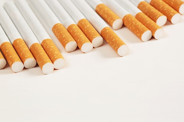 Imagen de varios cigarrillos de pila fabricados comercialmente sobre fondo blanco. o concepto de campaña para no fumadores, vista superior del patrón de tabaco.