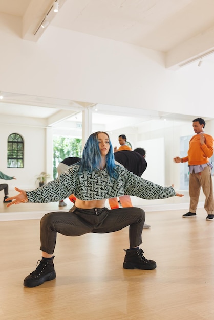 Foto imagen vertical de una bailarina caucásica de hip hop practicando en un estudio de danza con espacio para copiar. concepto de danza, ritmo, movimiento y entrenamiento.