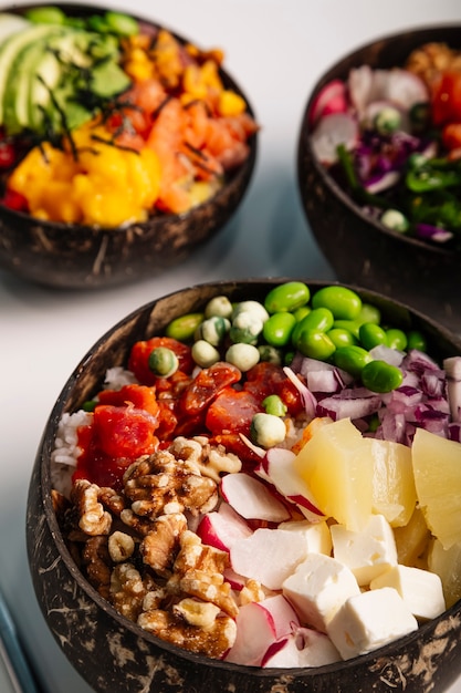 Imagen vertical cerca de Poke bowl con pescado, arroz y verduras frescas