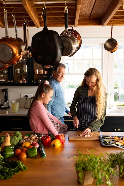 Foto imagen vertical de una feliz familia caucásica de varias generaciones preparando la cena juntos. concepto de familia y pasar tiempo de calidad juntos.